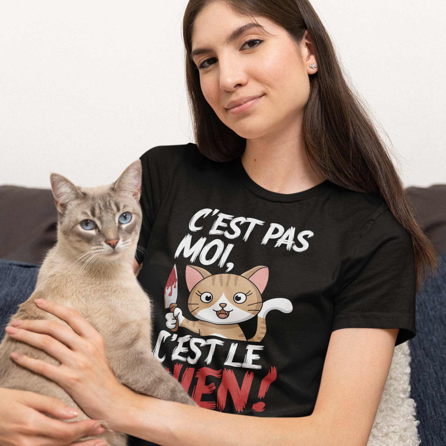 femme assise tenant un chat et portant un tshirt humour avec le design cest pas moi cest le chien