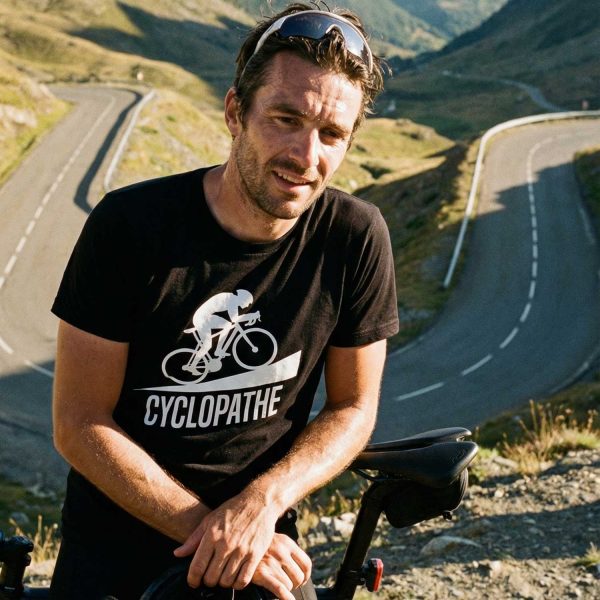 homme portant un t-shirt humour cyclopathe avec vélo sur une route de montagne
