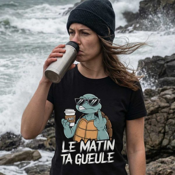 femme buvant un café au bord de la mer portant un t-shirt humour le matin ta gueule avec tortue grognon